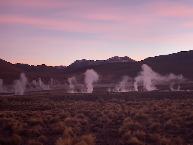 Gêiseres de El Tatio soltando vapor ao amanhecer no altiplano do Atacama