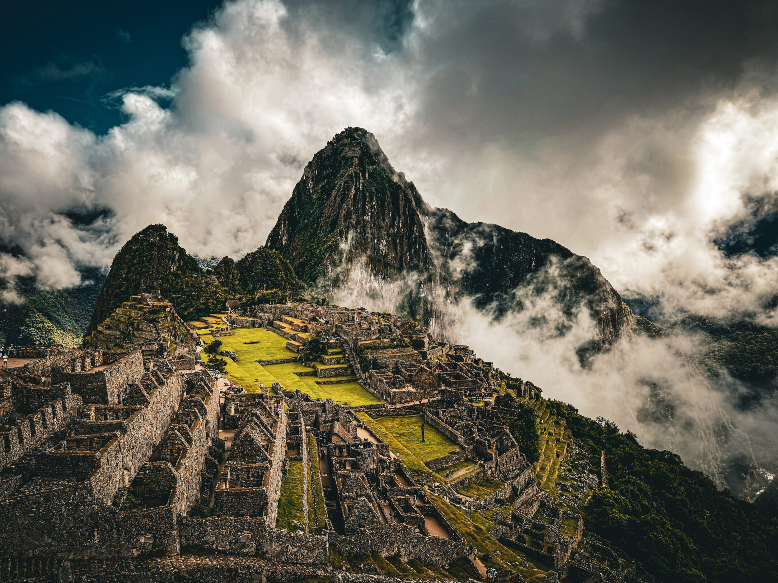 Machu Picchu entre nuvens, com os terraços incas e a montanha Huayna Picchu ao fundo